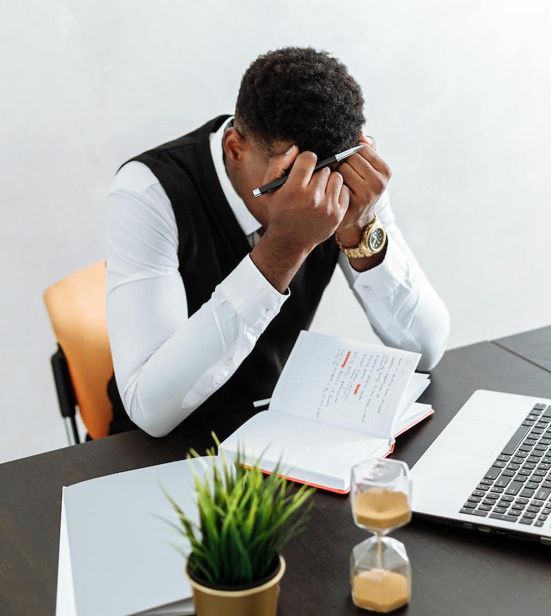 care concepts therapy man at desk with head in hands-min man at desk with head in hands