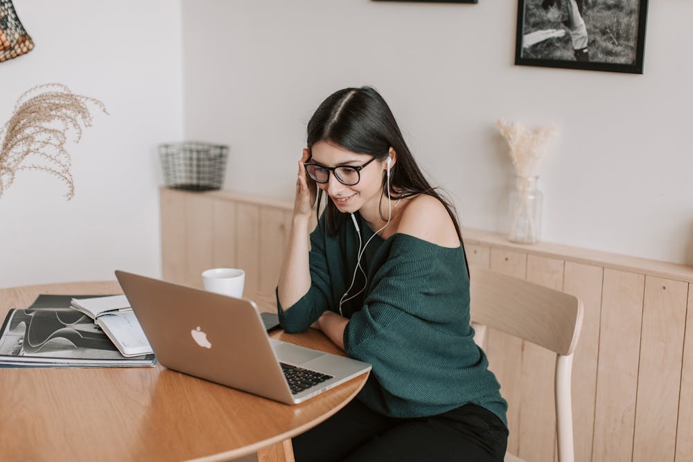 care concepts therapy smiling student in earphones watching laptop at table at home